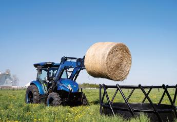Tractor lifting hay bale